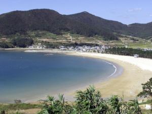 a view of a beach with mountains in the background at Namhae eunmorae pension in Namhae