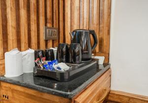 a counter with a coffee maker on top of it at Hotel Hamza in Srinagar +21 photos