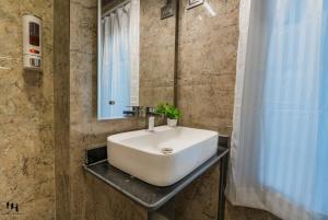 a bathroom with a white sink and a mirror at Hotel Hamza in Srinagar