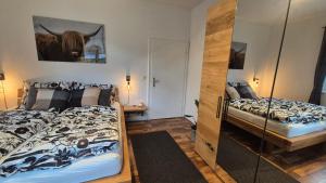 a bedroom with two beds and a glass door at Auszeitplatzl in Unken