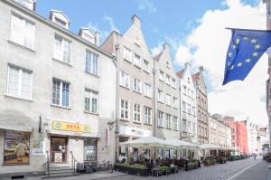 a city street with buildings and a flag at Złota Brama - Old Town Apartment 1 in Gdańsk
