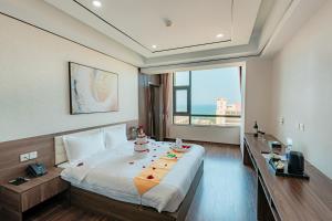 a hotel room with a bed with a cake on it at Long Hotel in Danang +70 photos