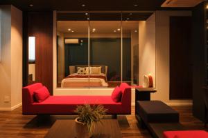 a living room with a red couch and a bed at Préciosité Chigasaki プレシオジテ茅ヶ崎 in Chigasaki