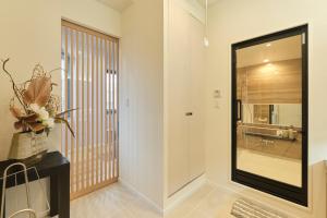 a hallway with a glass door leading to a bathroom at Préciosité Chigasaki プレシオジテ茅ヶ崎 in Chigasaki +79 photos