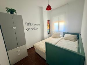 a small bedroom with a bed and a cabinet at Brisa de la Barrosa in Novo Sancti Petri