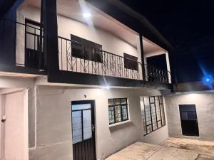 ein weißes Gebäude mit Balkon und Tür in der Unterkunft Casa Avus in Tetelco
