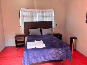ein Schlafzimmer mit einem Bett, auf dem zwei Handtücher liegen in der Unterkunft Casa Avus in Tetelco + 9 Fotos