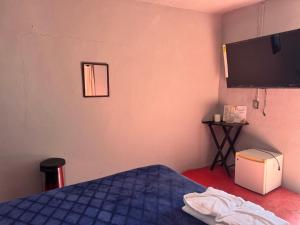 ein Schlafzimmer mit Bett und Flachbildfernseher in der Unterkunft Casa Avus in Tetelco