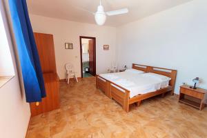 sypialnia z łóżkiem i drewnianą podłogą w obiekcie Hotel Residence Il Mulino w mieście Alicudi