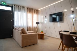 a living room with a couch and a table at DNS Elements Apartments 1 in Nea Karvali
