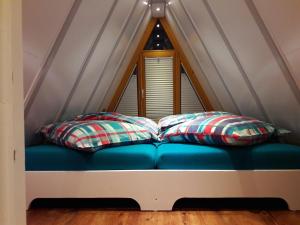 two pillows sitting on a blue couch in front of a window at Nurdachhaus Ferienpark Schellbronn in Schellbronn