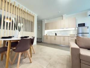 a kitchen with a table and chairs and a couch at DNS Elements Apartments 1 in Nea Karvali