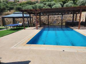 a swimming pool with a gazebo and a swimming pool at חלום בהר- 2 סוויטות מפנקות עם בריכה ואמבט ספא במתחם in ‘Ein el Asad
