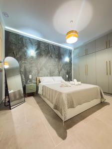 a bedroom with a large bed and a wall mural at DNS Elements Apartments 1 in Nea Karvali