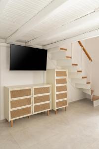 a living room with stairs and a flat screen tv at Aspronissos Hotel in Skiathos