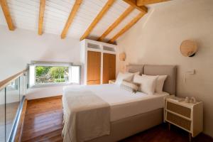 a bedroom with a large bed and a window at Aspronissos Hotel in Skiathos +38 photos