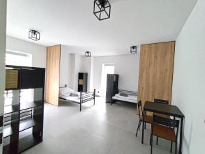 a living room with a table and a bedroom at Apartamenty DK8 in Szalejów Górny