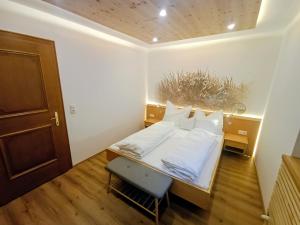 a small bedroom with a bed and a chair at Landhaus Rieder in Mittersill
