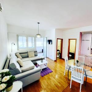 a living room with a couch and a table at Malinsummer Apartments in Malinska