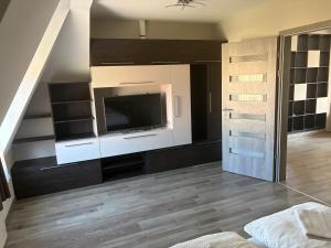 a living room with a flat screen tv on a wall at Lenti Central Apartman in Lenti