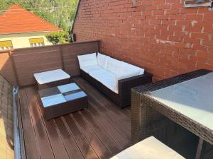 a balcony with a bench and a brick wall at Lenti Central Apartman in Lenti