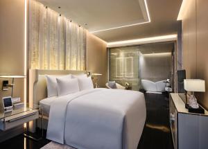 a bedroom with a large white bed and a desk at J Hotel, Shanghai Tower in Shanghai