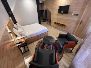 a hotel room with a bed and a table and chairs at Eat and Read Hotel in Skardu