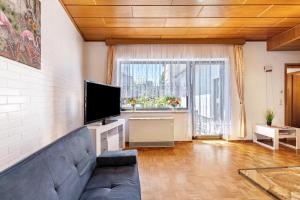 a living room with a couch and a flat screen tv at Ferienhaus Eiffelperle in Kaisersesch