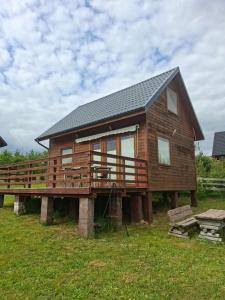 a large wooden house on a platform in a field at Całoroczny dom letniskowy in Chmielno