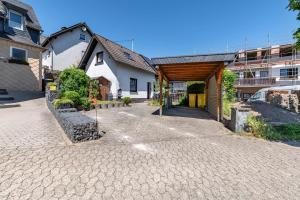 a house with a brick driveway in front of a building at Ferienhaus Eiffelperle in Kaisersesch