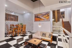 a living room with a table and a dining room at EKOSTAY - Mount Emerald Villa in Alibaug