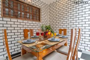 a dining room with a wooden table with chairs at EKOSTAY - Mount Emerald Villa in Alibaug +24 photos