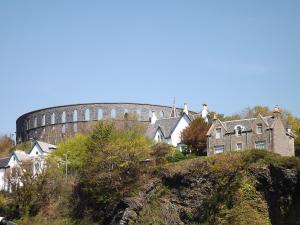 a building on top of a hill with houses at Palace Hotel - Small Hotel in Oban