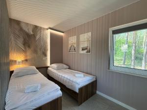two beds in a room with a window at Turawa Lake Residence in Turawa