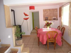 un comedor con mesa, sillas y una planta en Gite 4* L'Orée des Fleurs, en Grézillé