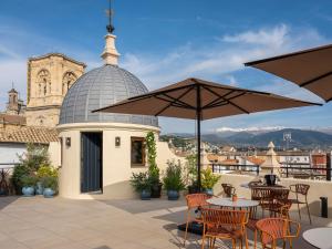 a patio with tables and umbrellas on a roof at Seda Residences in Granada