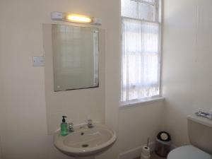 a white bathroom with a sink and a mirror at Palace Hotel - Small Hotel in Oban +20 photos