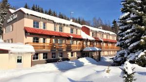 a large building in the snow with snow covered trees at Hotel Bon in Tanvald