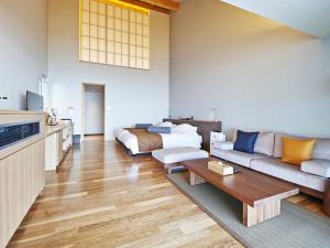 a living room with a couch and a table at さざね in Kyonan