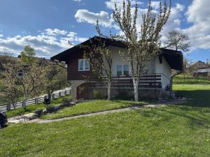 a house with a tree in the yard at Vikend kuća Planinski raj in Pale