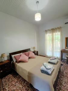 a bedroom with a large bed with pink pillows at House Konstantinos in Agios Georgios +37 photos