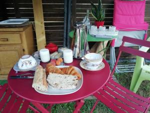 a red table with a plate of bread on it at Le cocon de Lili et de Patrick in Draveil +5 photos