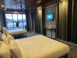 a hotel room with two beds and a television at Eat and Read Hotel in Skardu