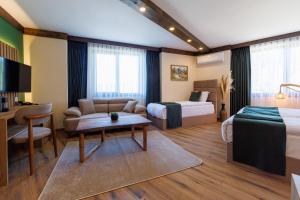a hotel room with two beds and a couch and a table at Sote Mountain View in Samokov