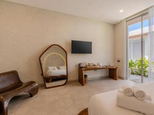 a bedroom with a mirror and a bed and a desk at Kala Lombok Hotel in Kuta Lombok