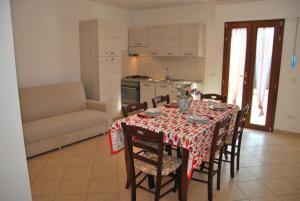 a dining room with a table and chairs and a kitchen at Appartamenti Margherita in Campo nell'Elba