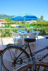 a bike parked next to a table with an umbrella at Appartamenti Margherita in Campo nell'Elba