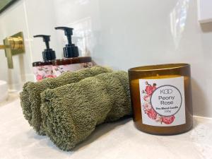 a candle sitting on a counter next to a towel at Wisteria Hideaway in Coffs Harbour