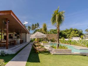 a backyard with a swimming pool and a house at Kala Lombok Hotel in Kuta Lombok