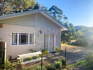a small house with a bench in front of it at Wisteria Hideaway in Coffs Harbour